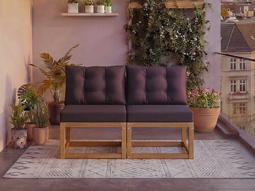 Divvietīgs modulārs koka dīvāns ar tum&scaron;i pelēkiem spilveniem uz balkona, ko ieskauj podu augi un fona pilsētas skats