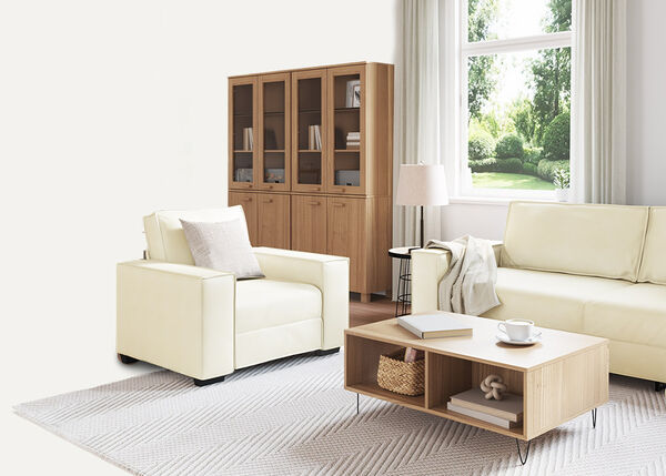 Balta divvietīga dīvāna ar spilveniem un pārklāju, telpās.